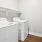 a white laundry room with a white laundry machine